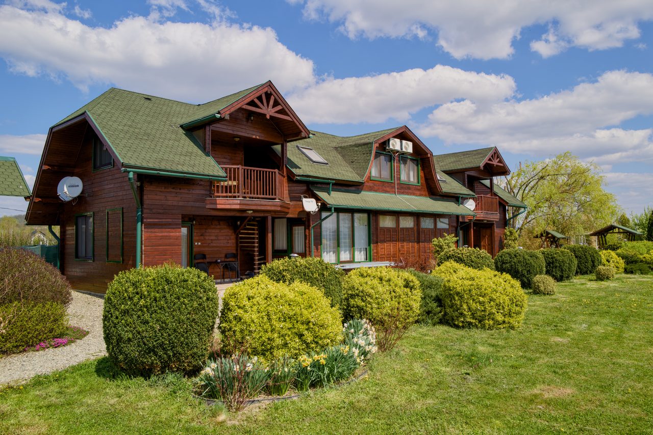 Casa de lemn văzută din curte